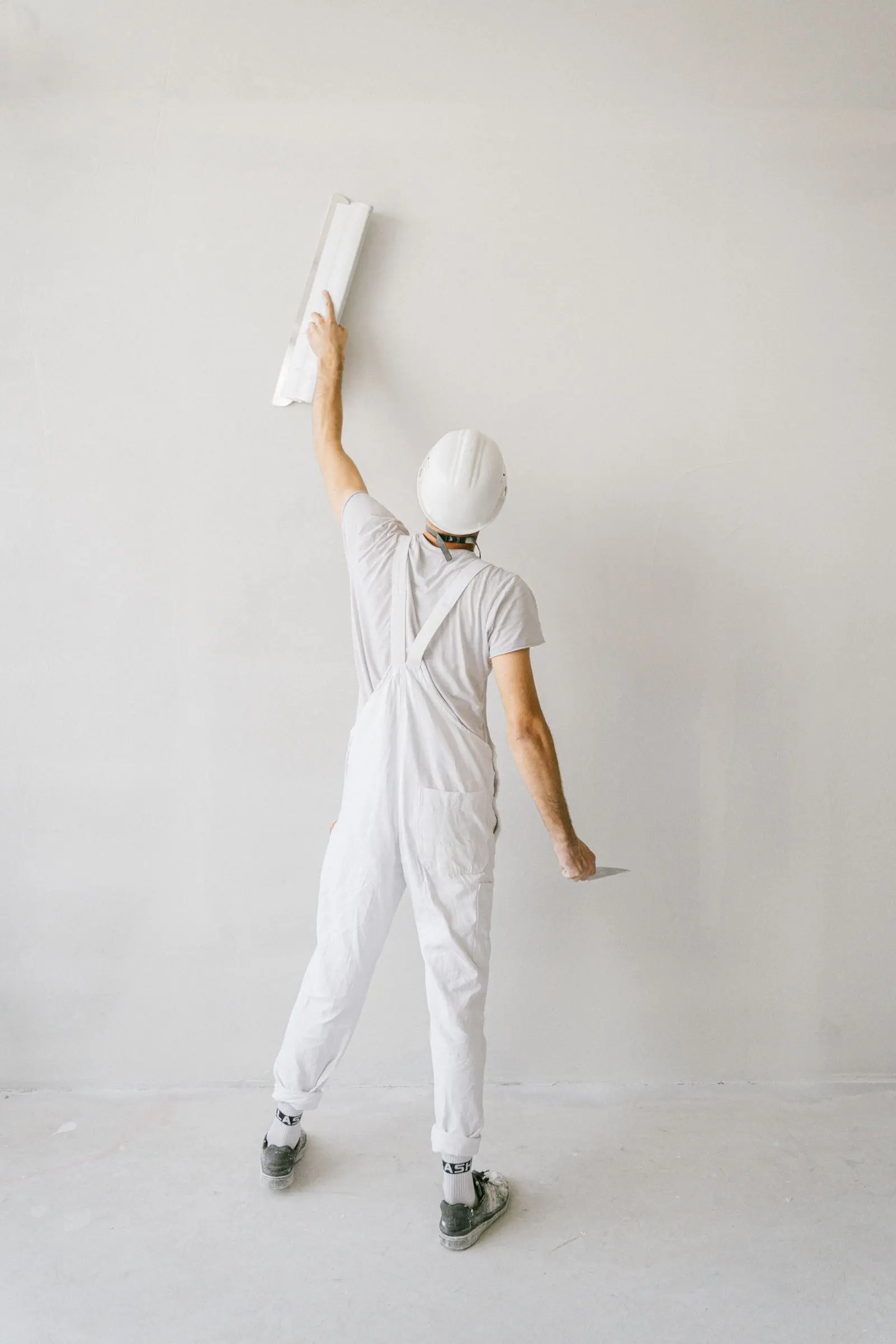 Peintre ERASIC appliquant une couche sur un mur